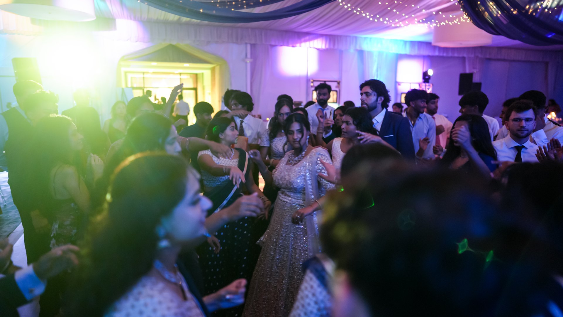 Guests on a packed dance floor with concert-style lighting — One Idea Entertainment