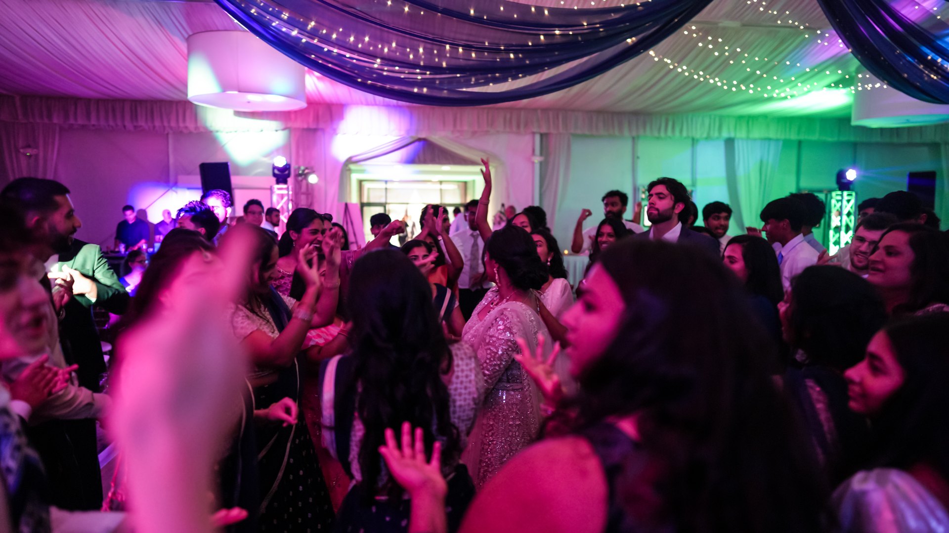 Guests on a packed dance floor with concert-style lighting — One Idea Entertainment