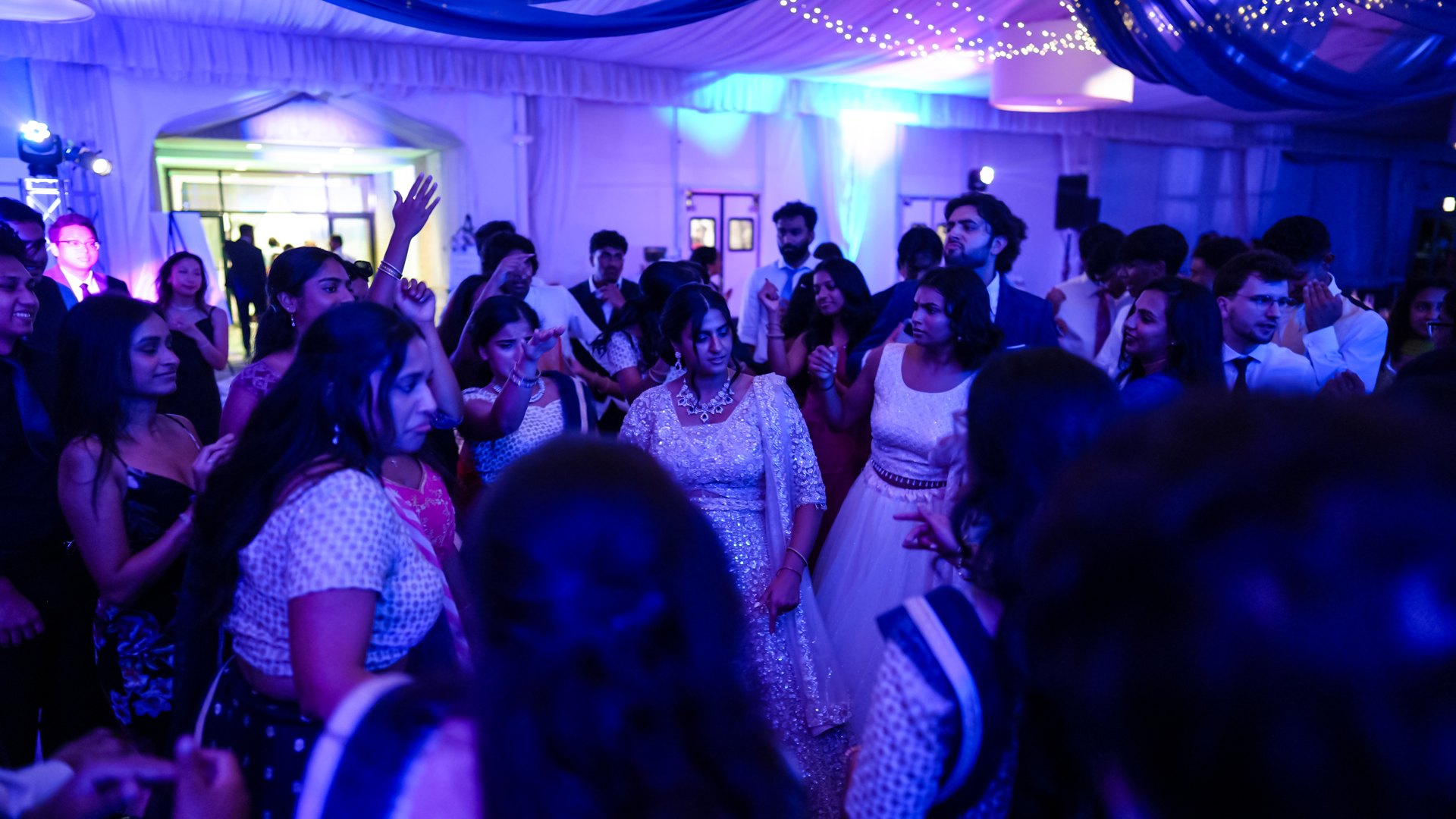 Guests on a packed dance floor with concert-style lighting — One Idea Entertainment
