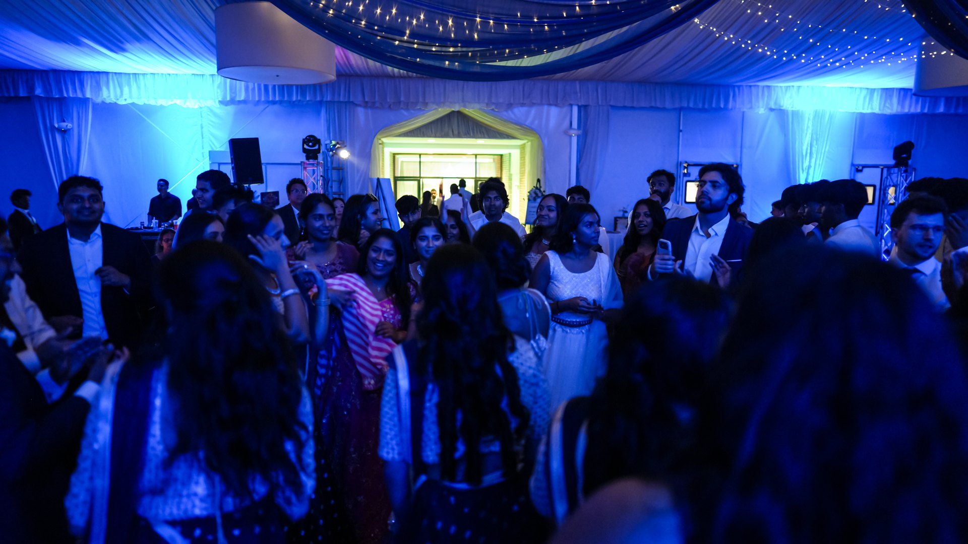 Guests on a packed dance floor with concert-style lighting — One Idea Entertainment