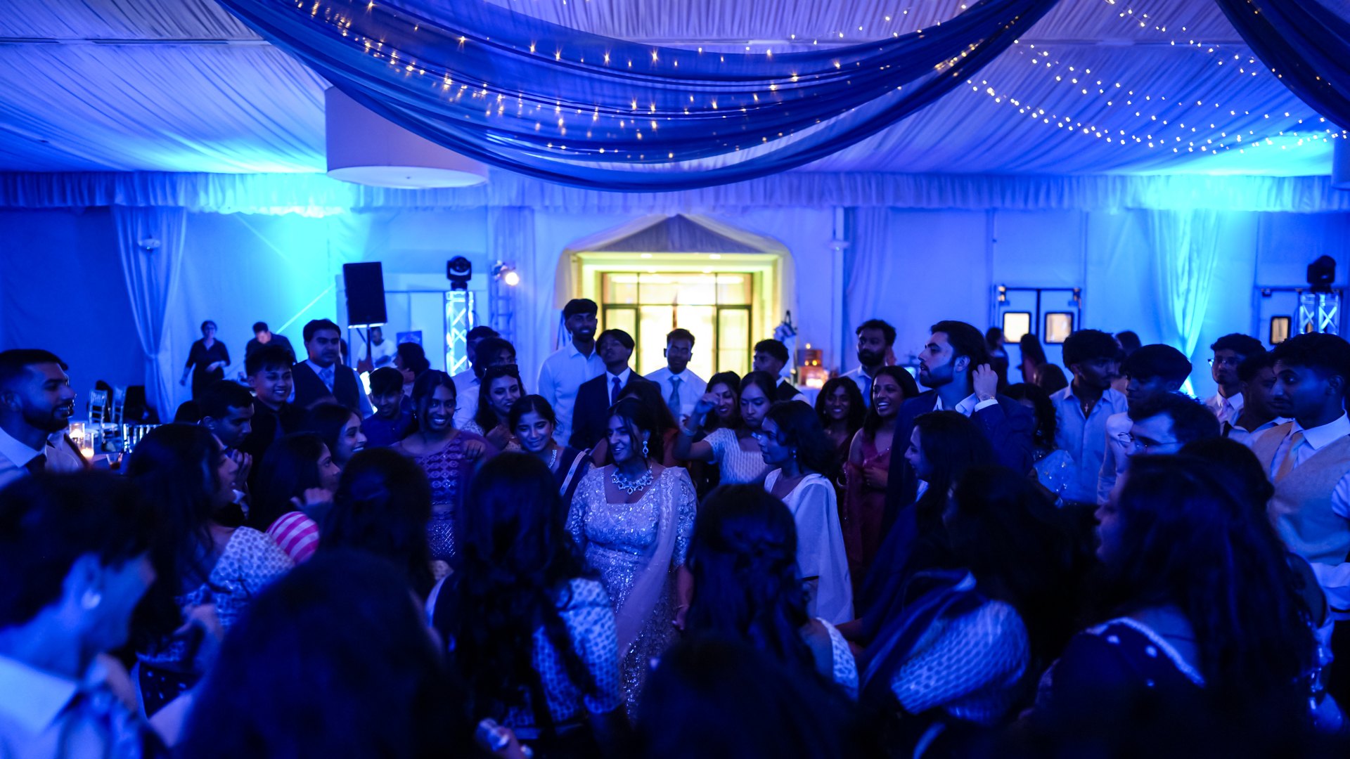 Guests on a packed dance floor with concert-style lighting — One Idea Entertainment