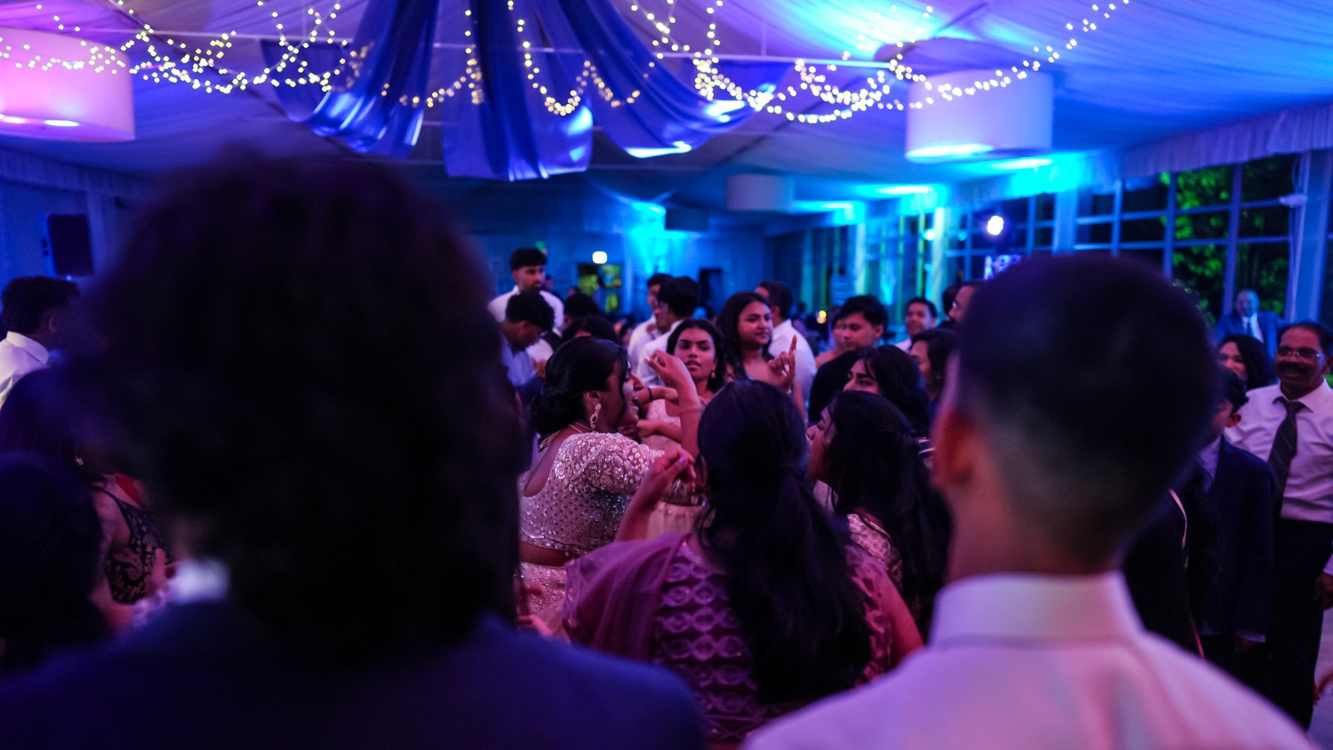 Guests on a packed dance floor with concert-style lighting — One Idea Entertainment