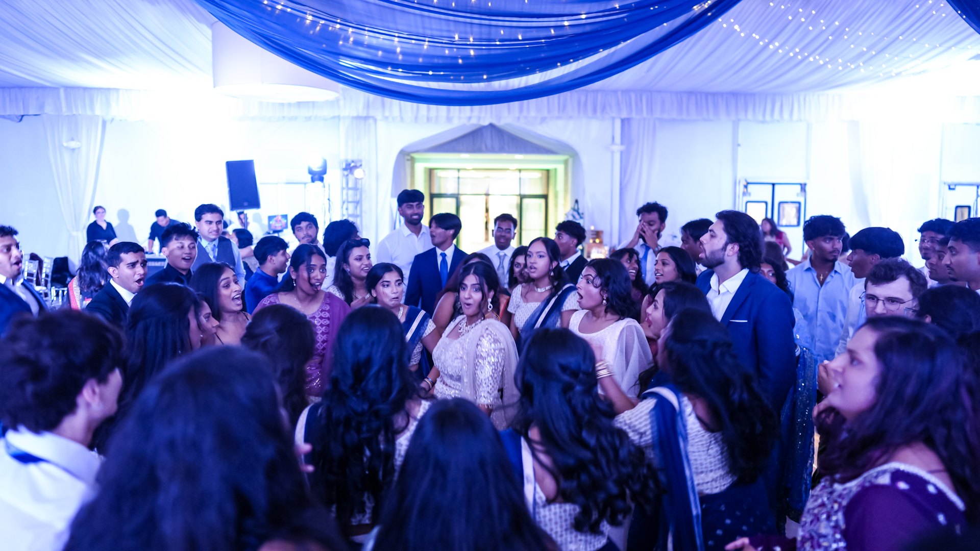 Guests on a packed dance floor with concert-style lighting — One Idea Entertainment