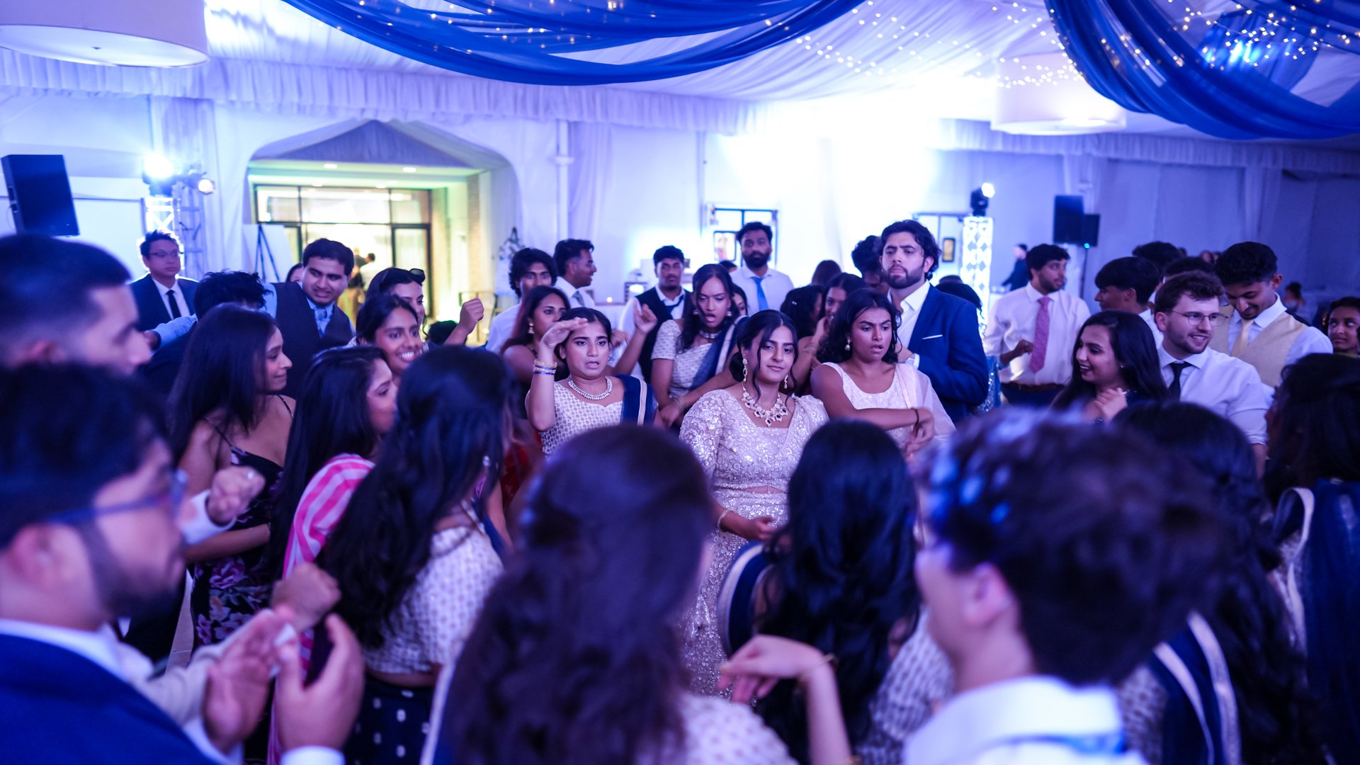 Guests on a packed dance floor with concert-style lighting — One Idea Entertainment