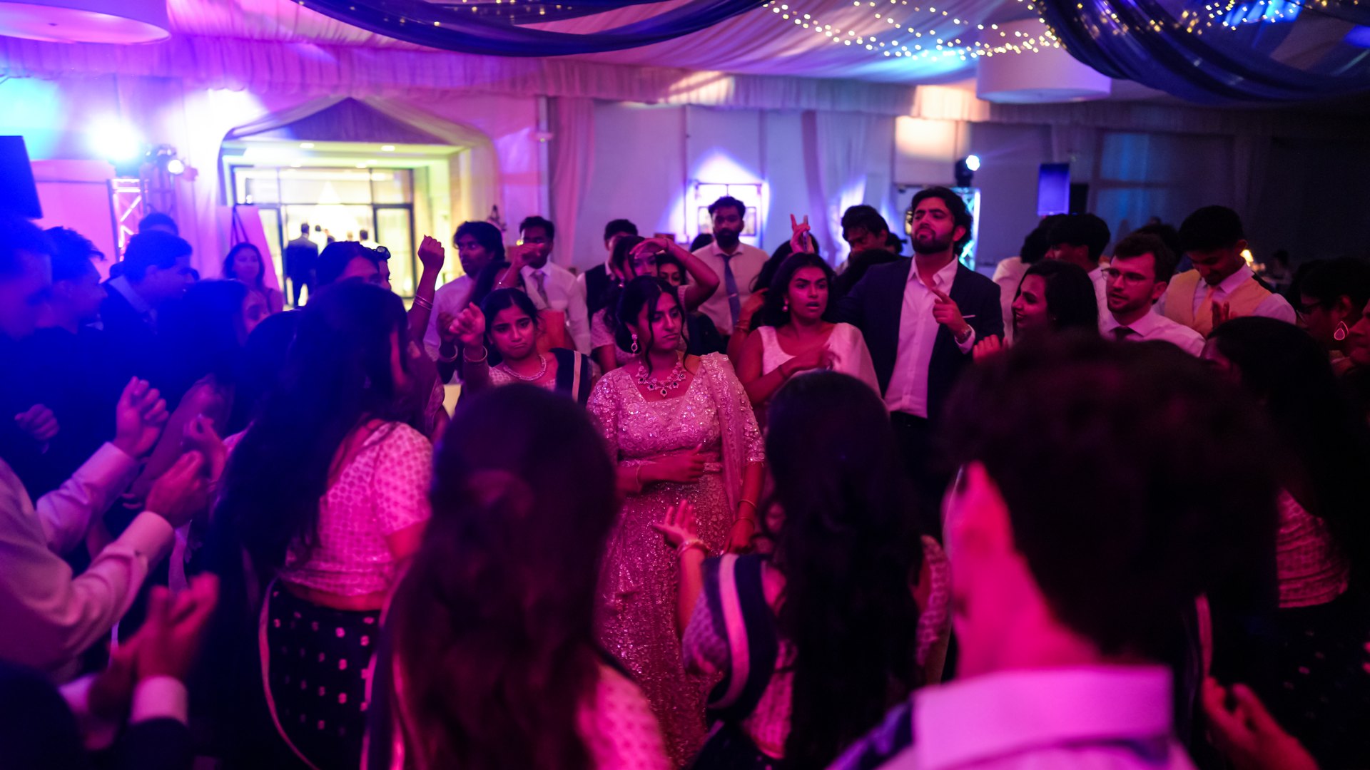 Guests on a packed dance floor with concert-style lighting — One Idea Entertainment