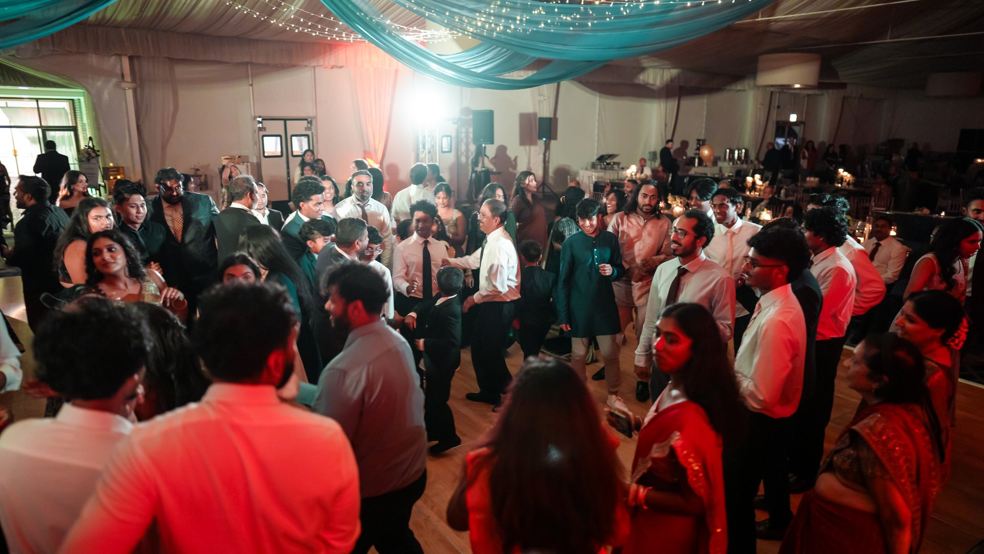 Guests on a packed dance floor with concert-style lighting — One Idea Entertainment