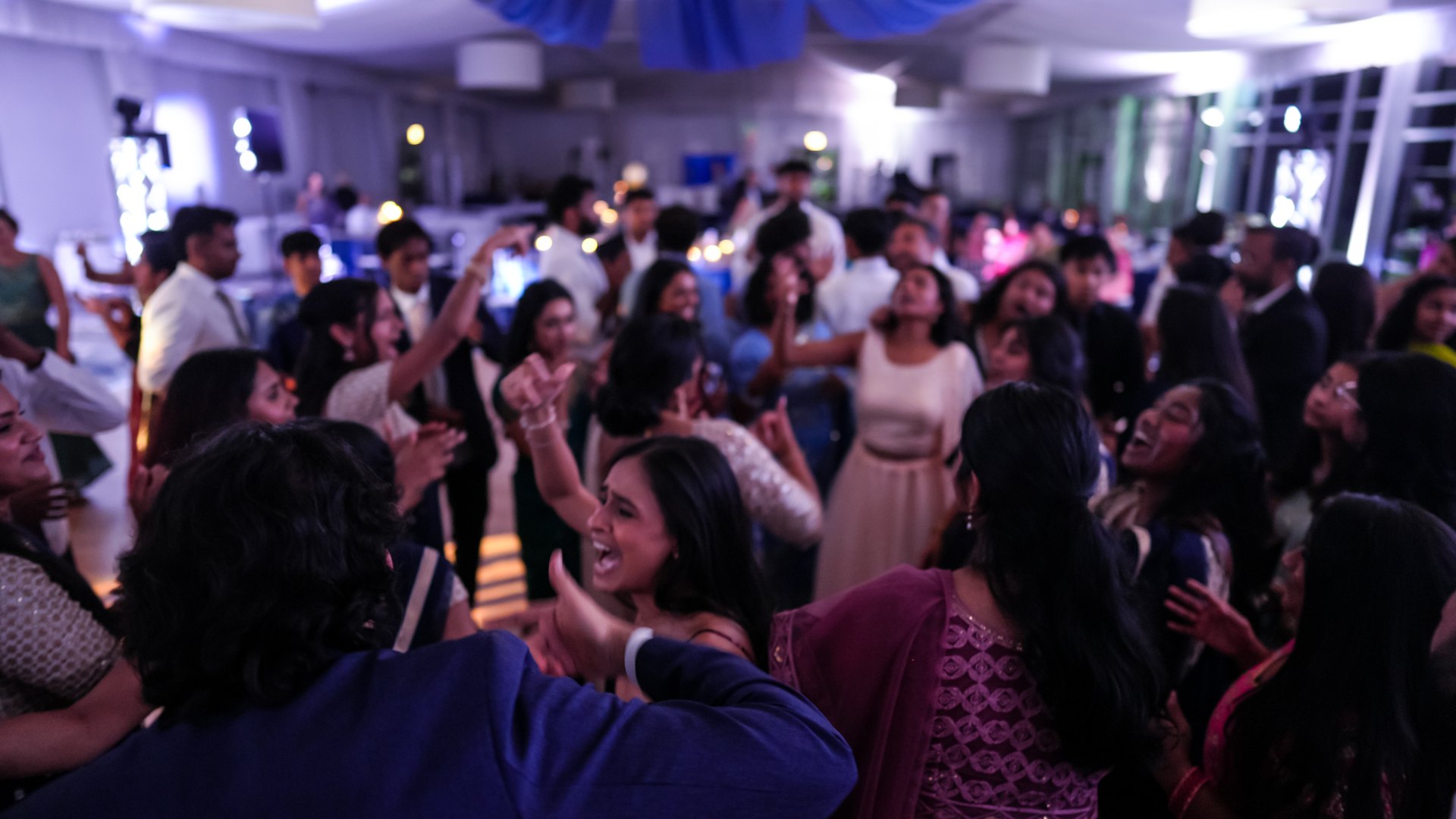 Guests on a packed dance floor with concert-style lighting — One Idea Entertainment