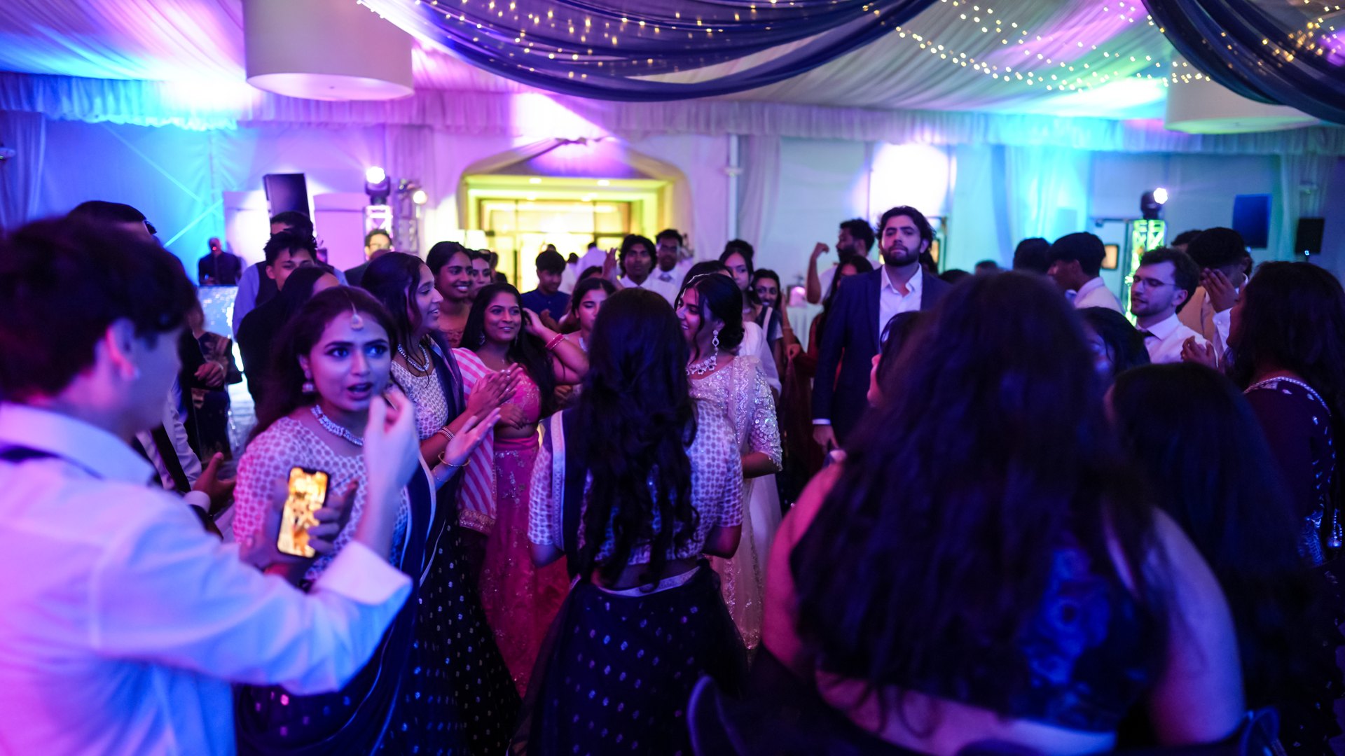 Guests on a packed dance floor with concert-style lighting — One Idea Entertainment