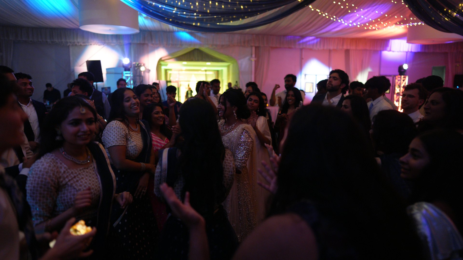 Guests on a packed dance floor with concert-style lighting — One Idea Entertainment