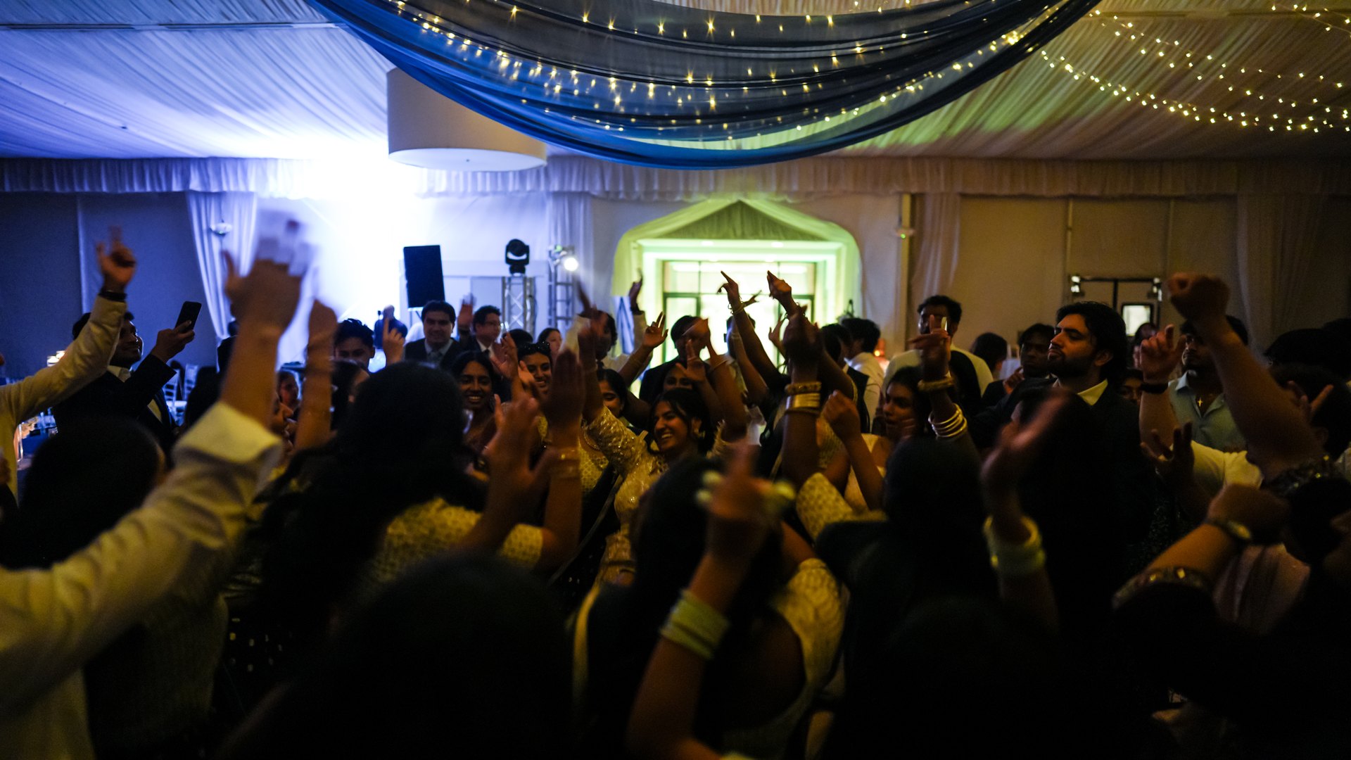 Guests on a packed dance floor with concert-style lighting — One Idea Entertainment