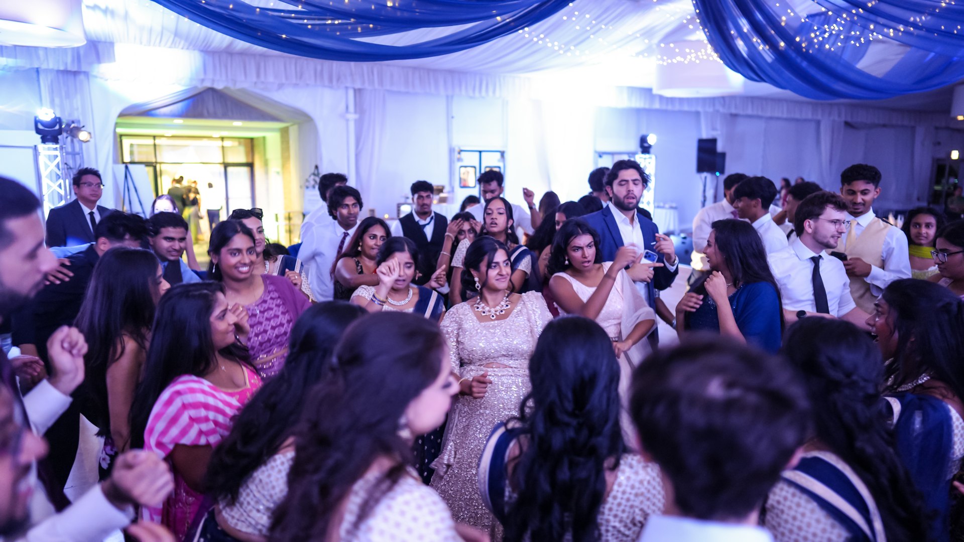 Guests on a packed dance floor with concert-style lighting — One Idea Entertainment