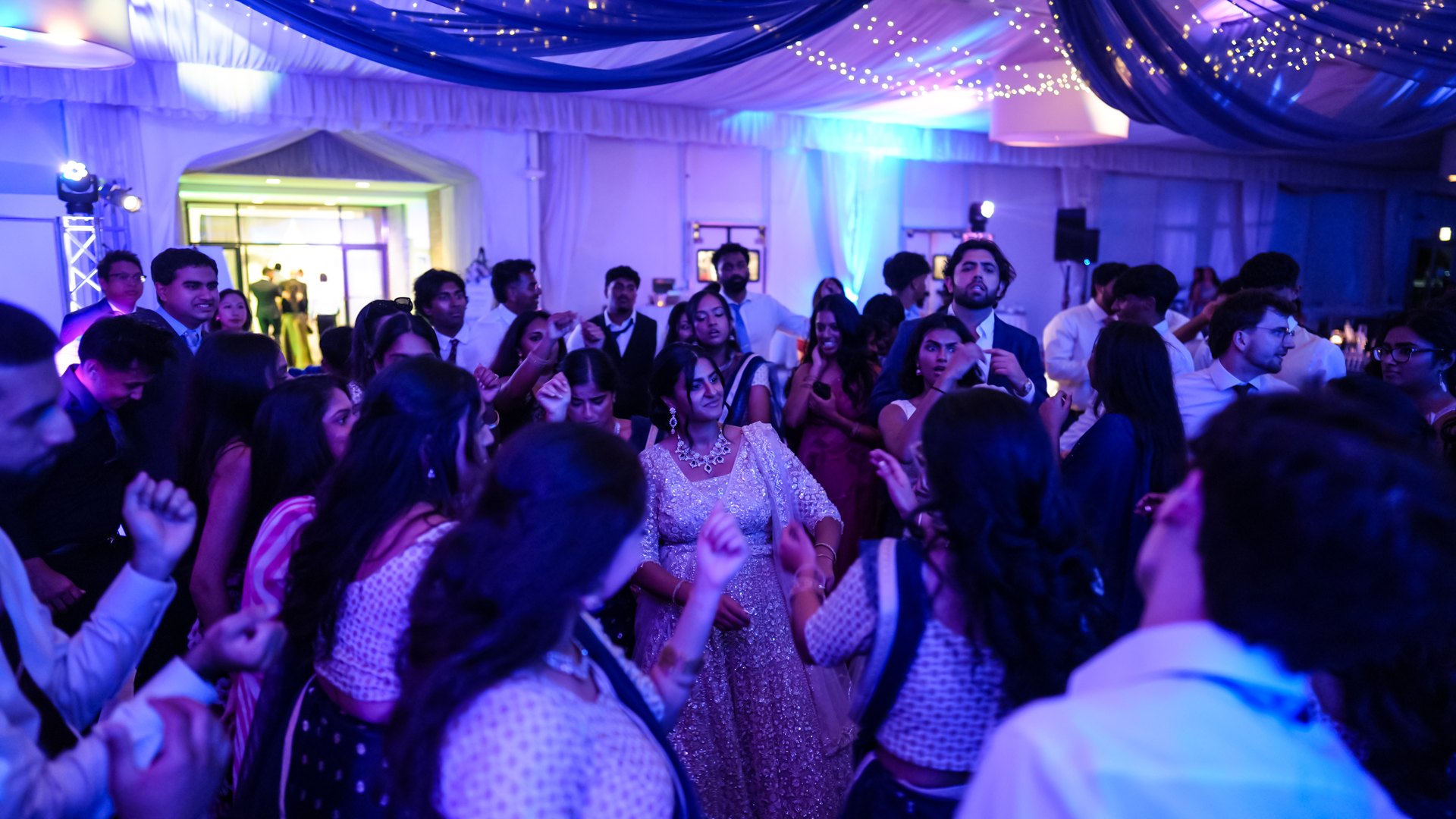 Guests on a packed dance floor with concert-style lighting — One Idea Entertainment