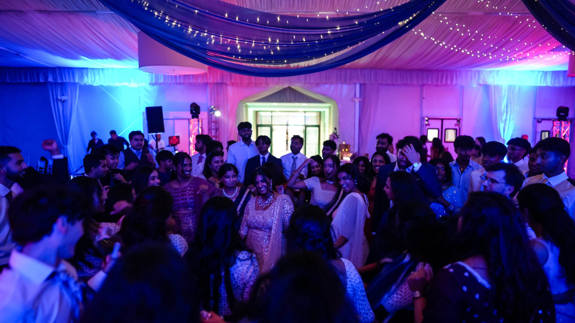 Guests on a packed dance floor with concert-style lighting — One Idea Entertainment