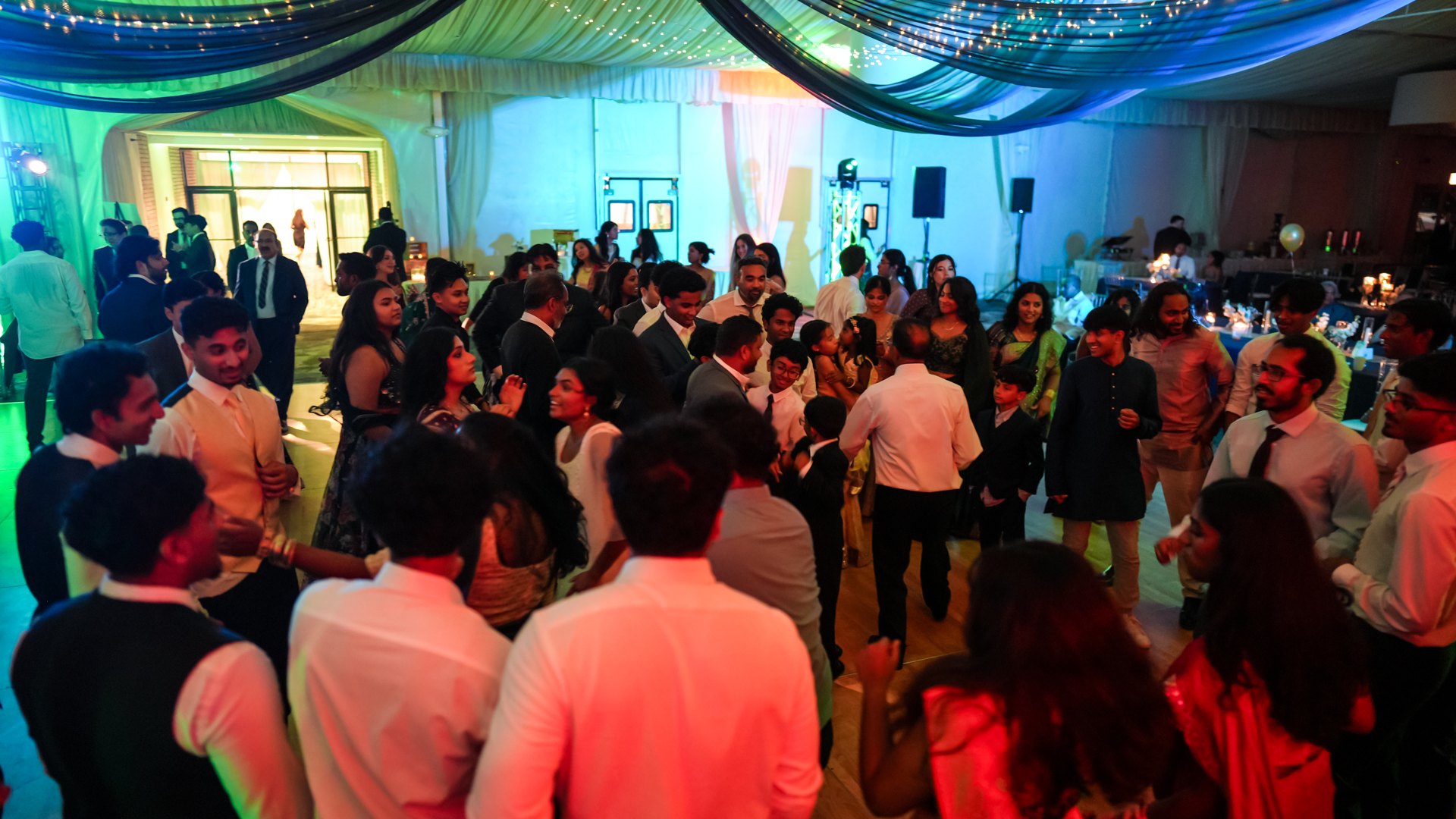 Guests on a packed dance floor with concert-style lighting — One Idea Entertainment