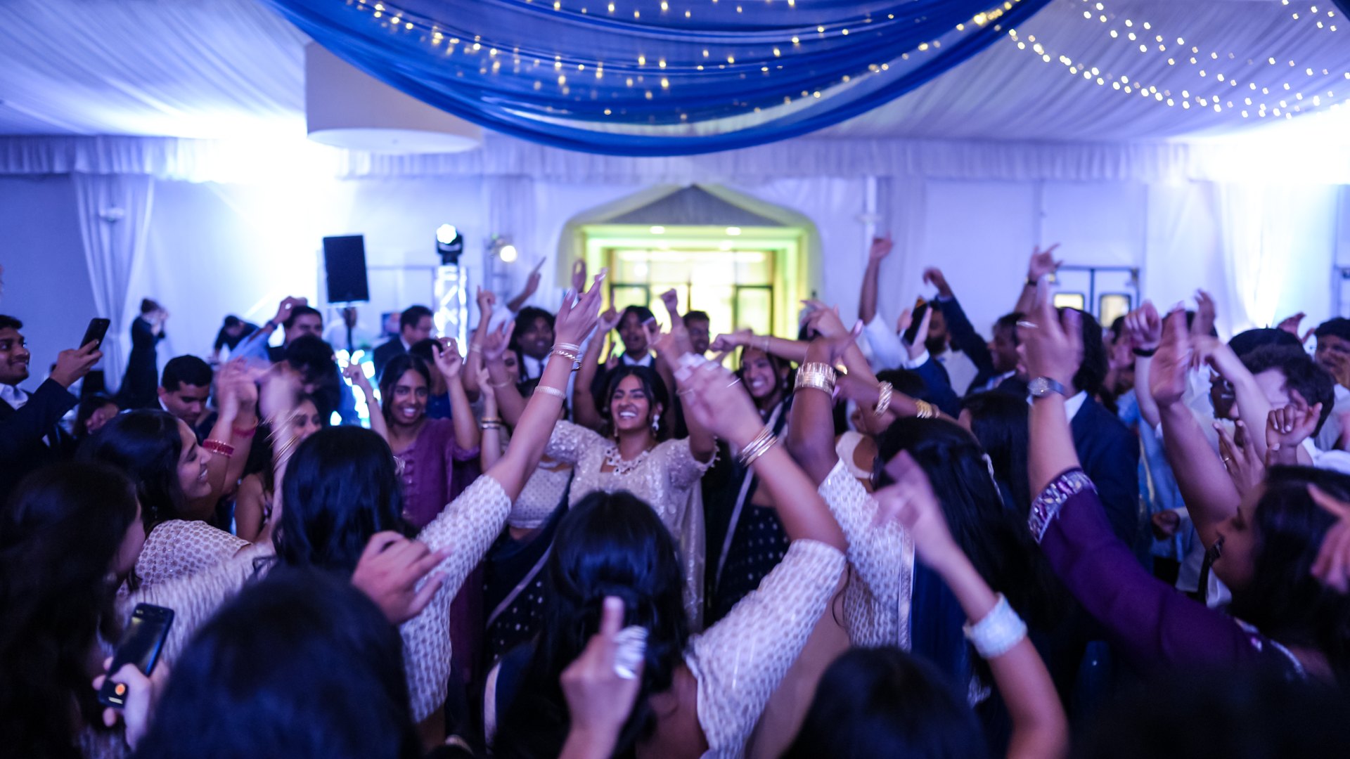 Guests on a packed dance floor with concert-style lighting — One Idea Entertainment