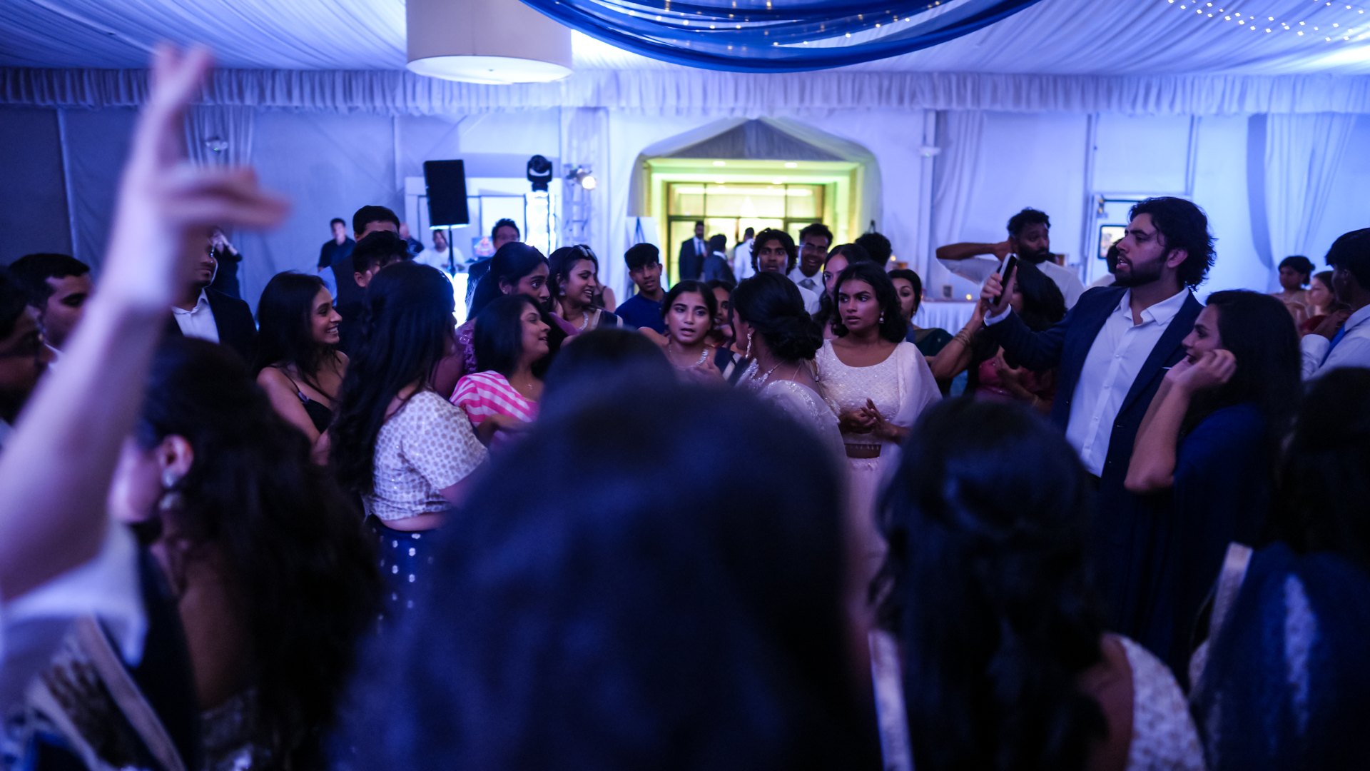 Guests on a packed dance floor with concert-style lighting — One Idea Entertainment