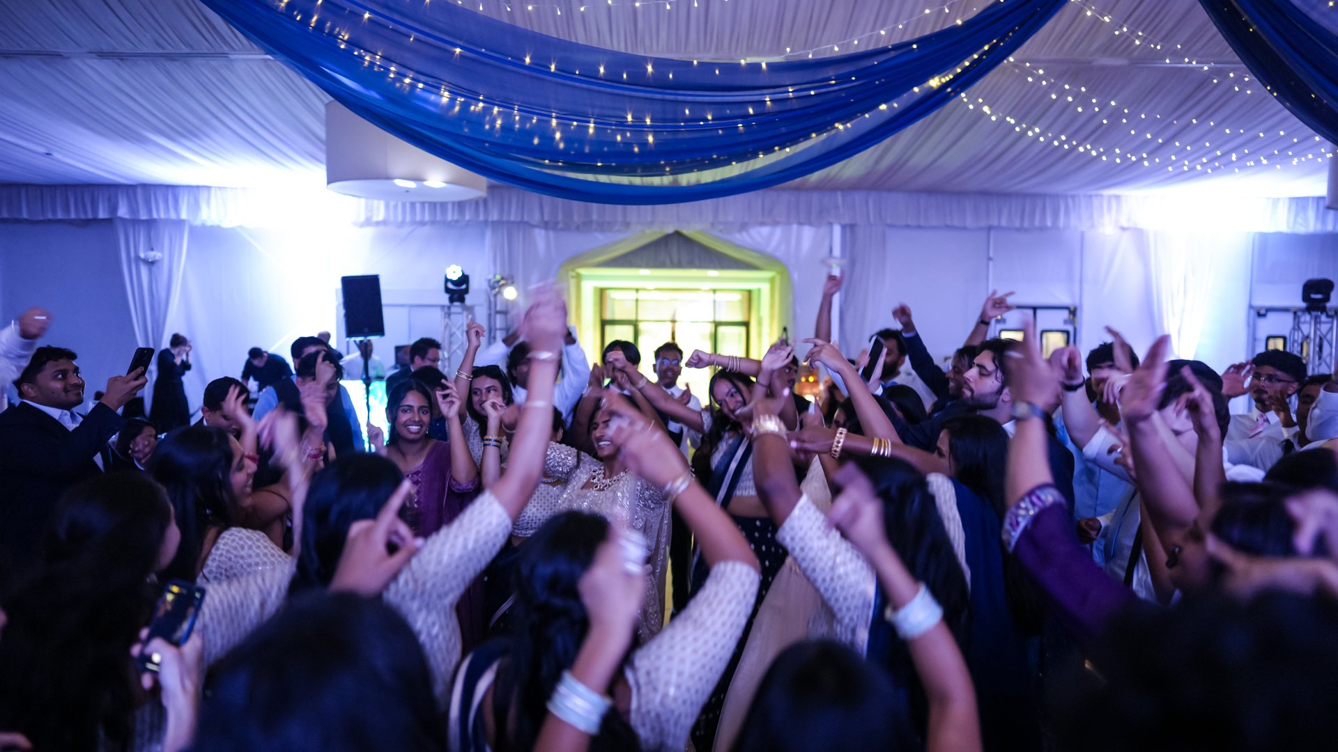 Guests on a packed dance floor with concert-style lighting — One Idea Entertainment